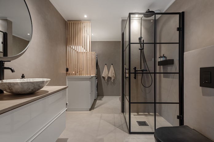 A bathroom with a sink, mirror, toilet and shower