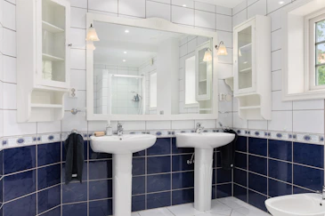 A bathroom with two sinks and a mirror