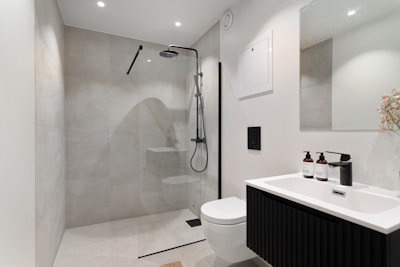 A bathroom with a toilet, sink, and shower