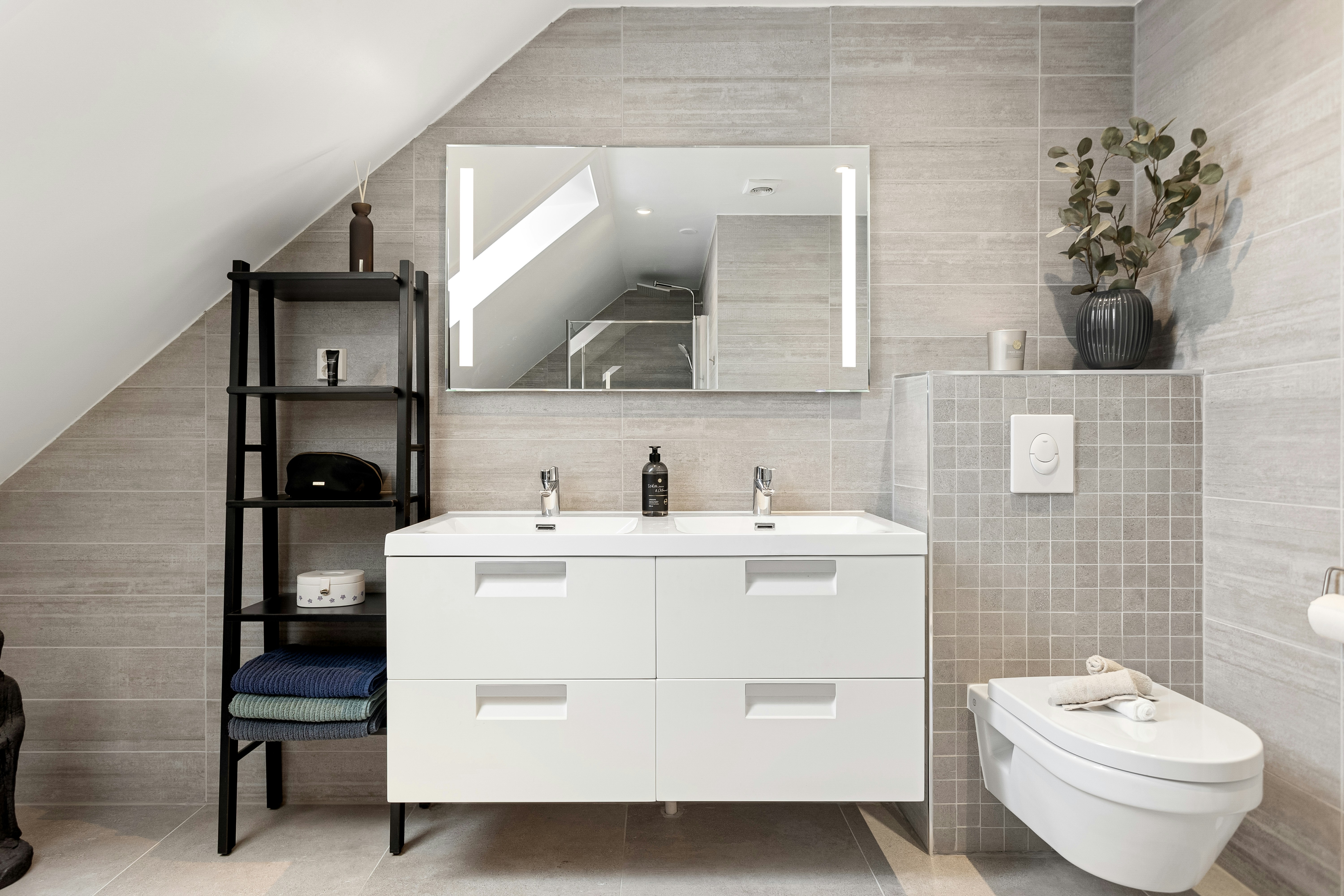 A bathroom with a toilet, sink, and mirror