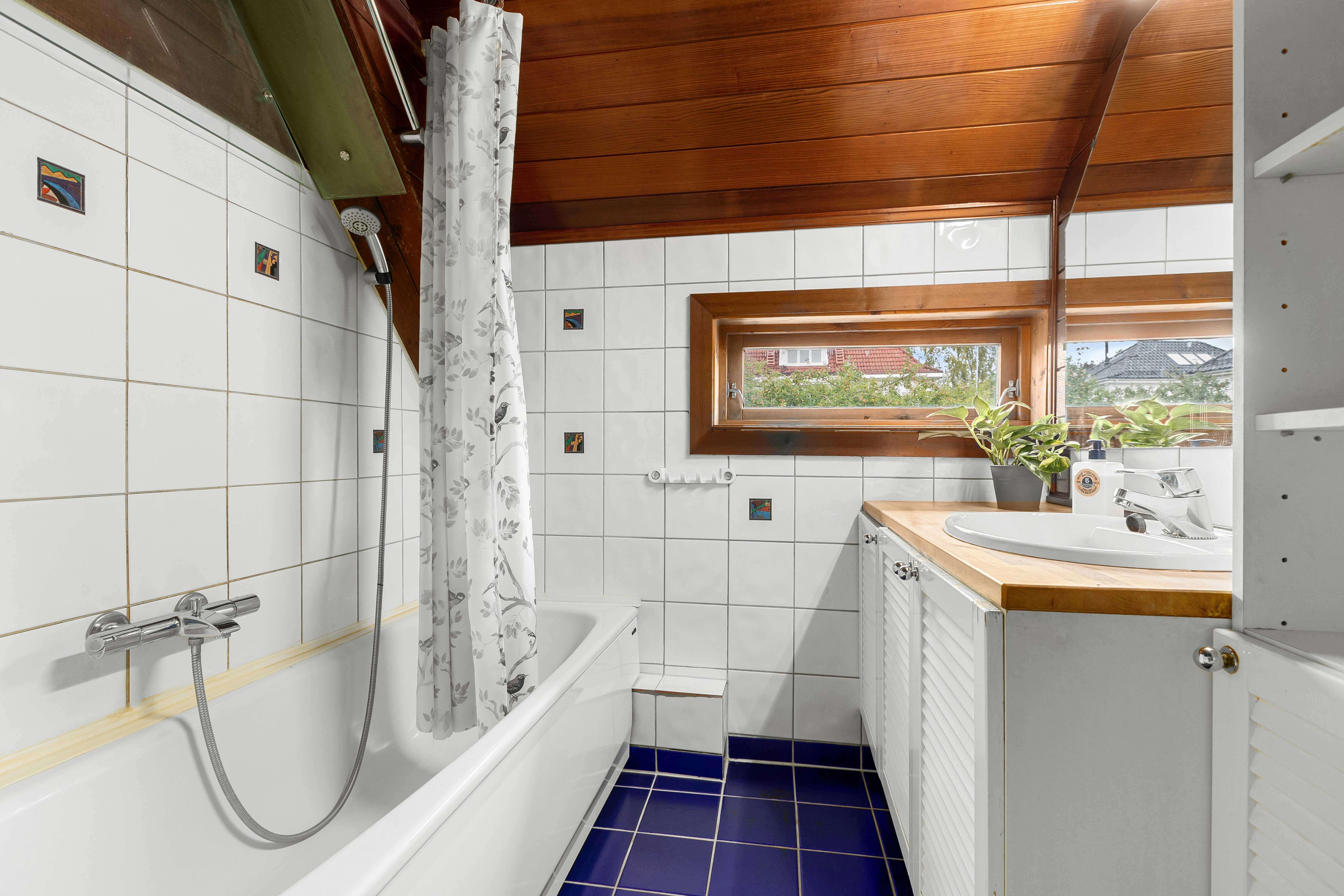 A bathroom with a tub, sink, and window