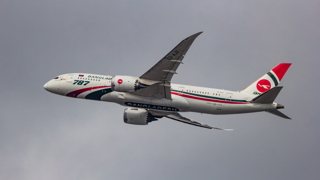 A large jetliner flying through a cloudy sky, Biman Bangladesh Airlines. Boeing 787-8 Dreamliner taking off from VGHS Dh