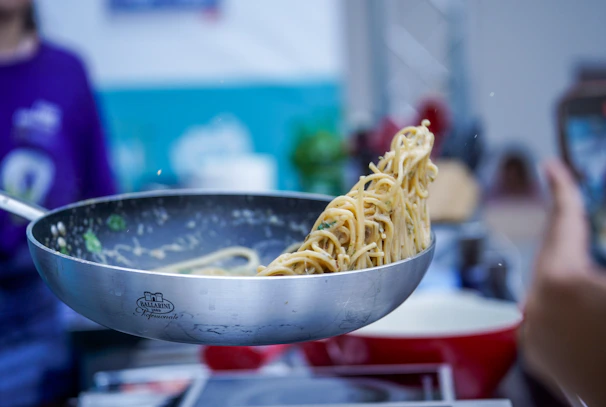 A person taking a picture of a bowl of noodles