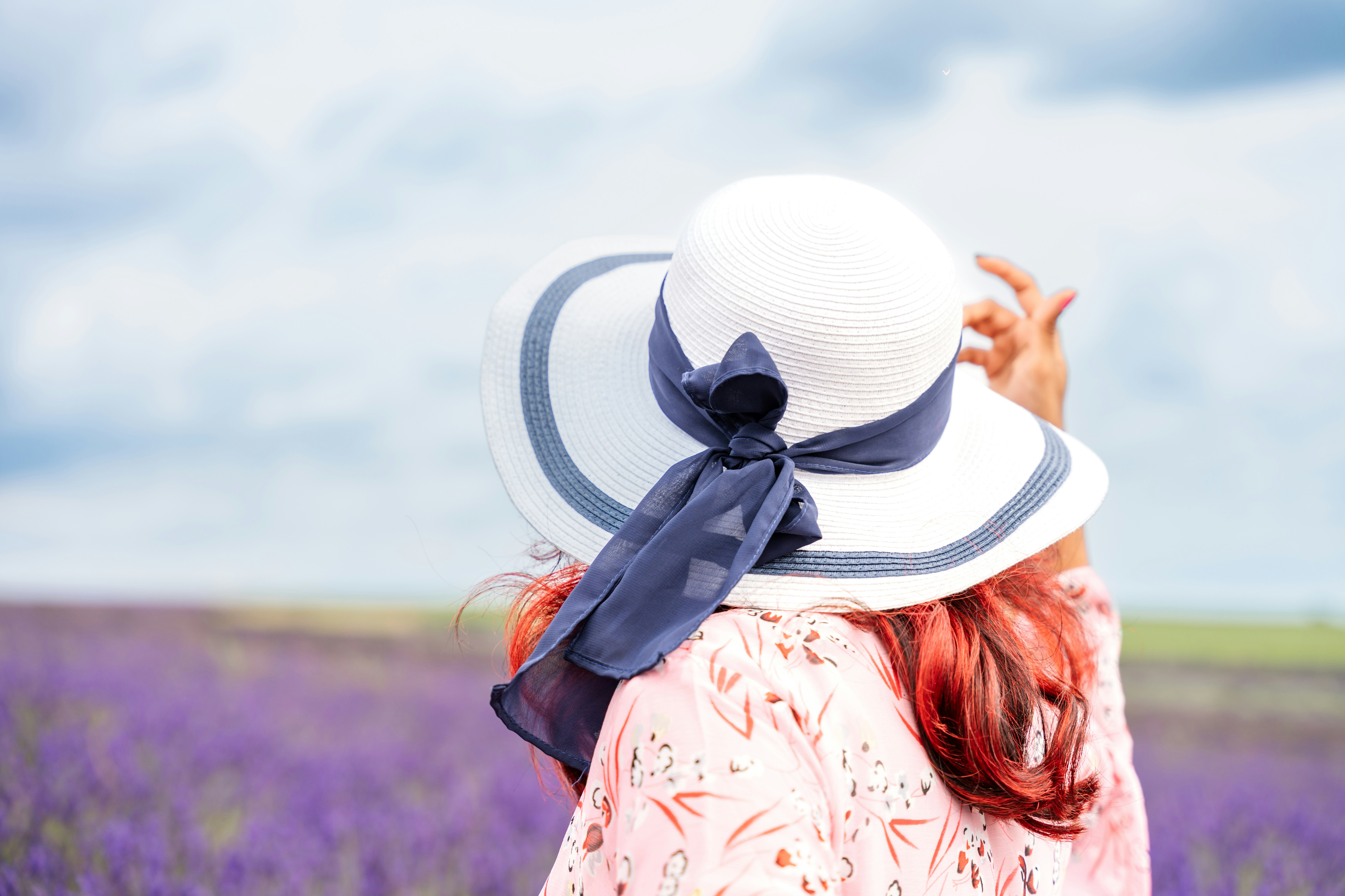 A woman in a hat standing in a lavender field