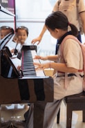 A group of young children sitting around a piano