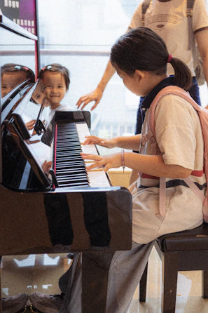 A group of young children sitting around a piano