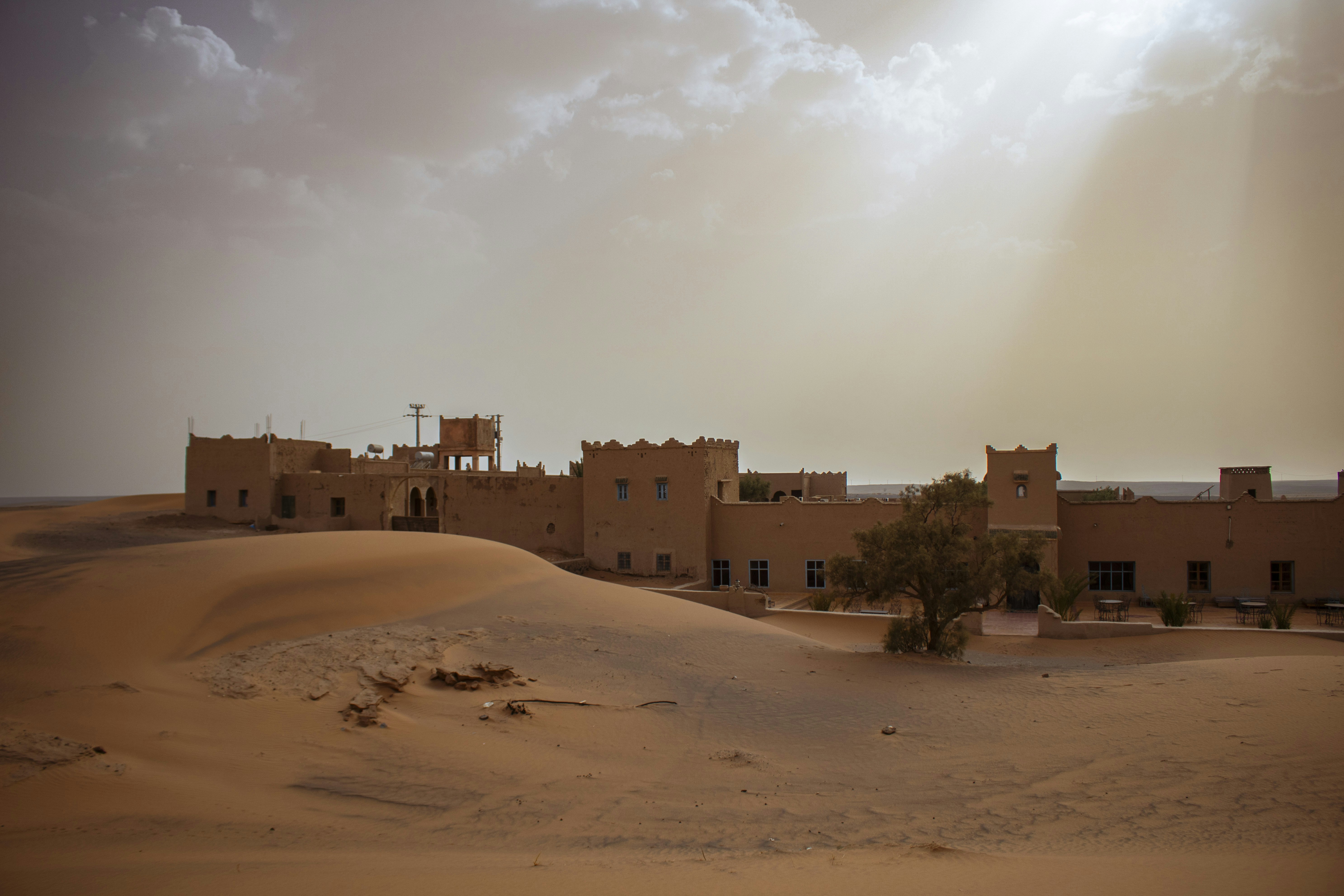 A desert scene with a building in the middle of the desert
