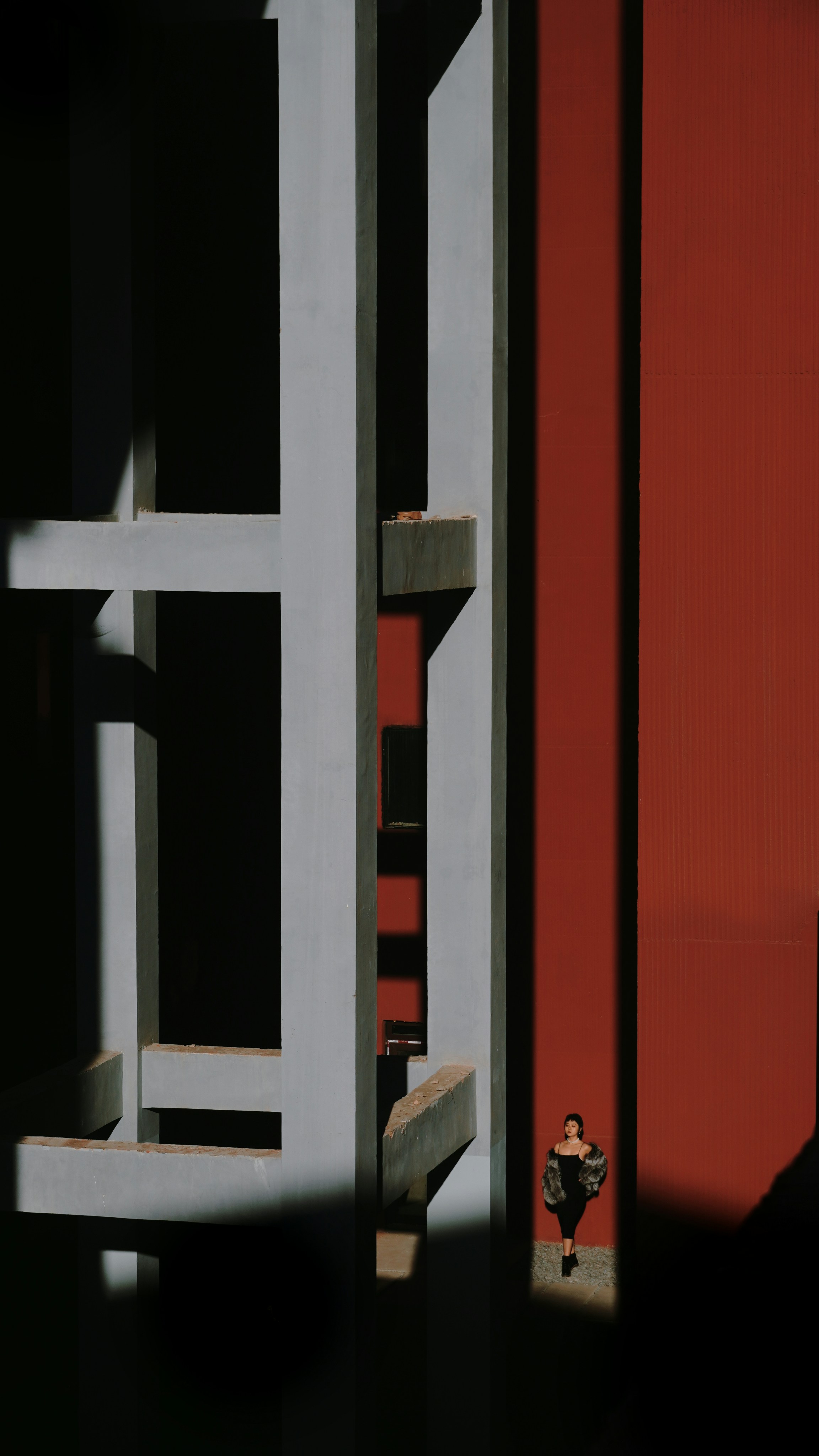 A person standing in front of a red building
