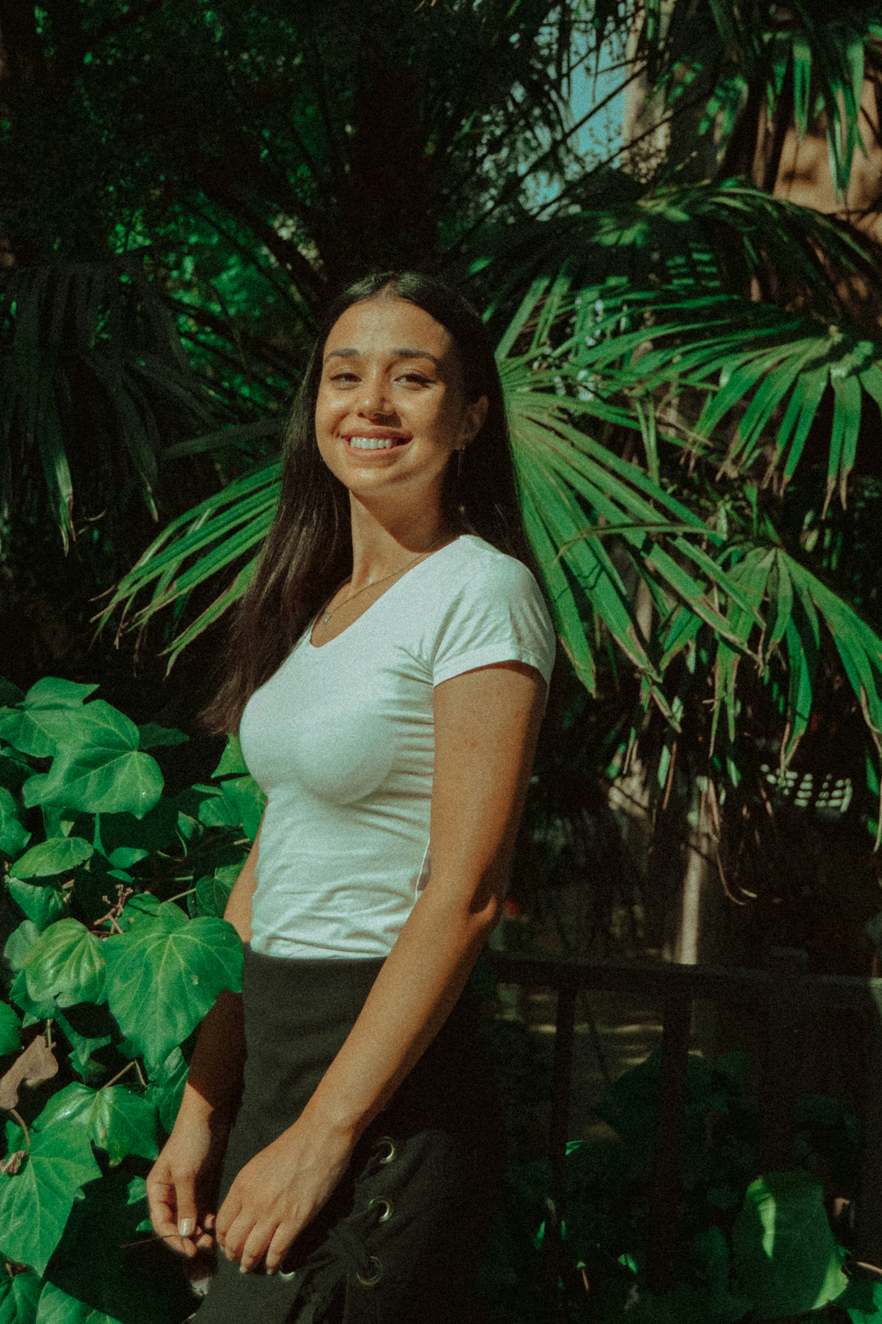 A woman standing in front of a lush green tree photo – Free Smile Image ...