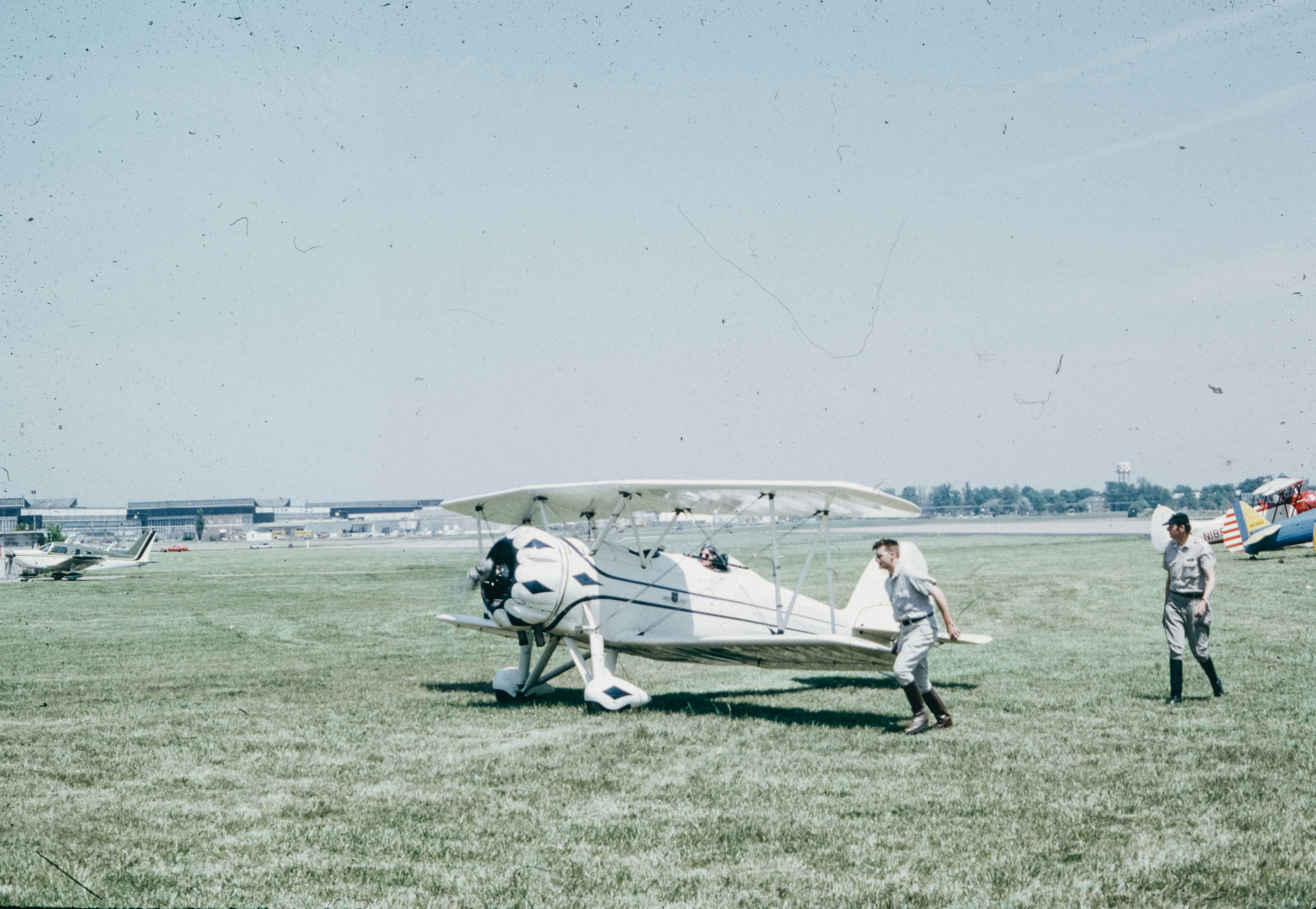 A group of people standing around a small plane, 
