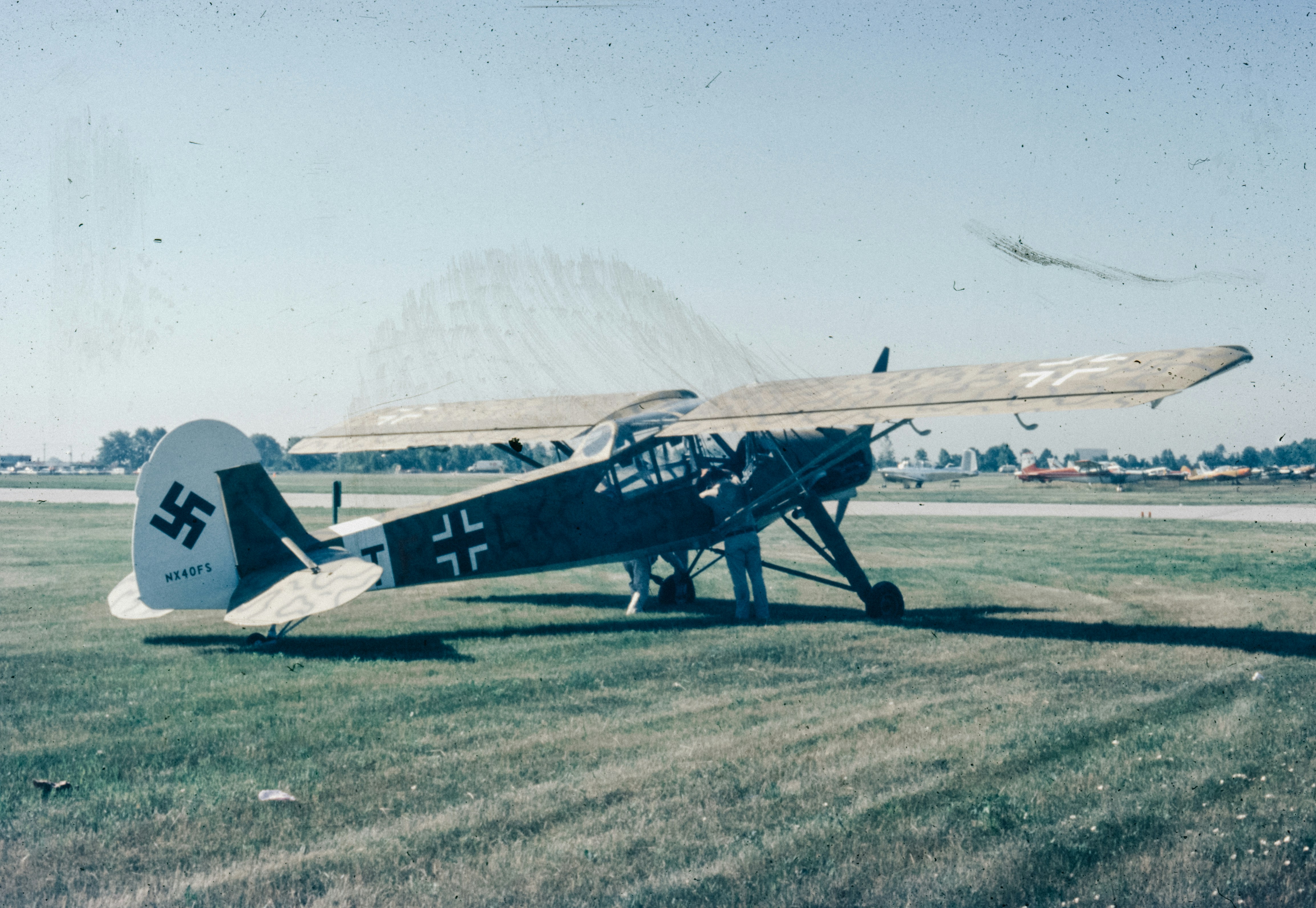 A small airplane sitting on top of a grass covered field, 