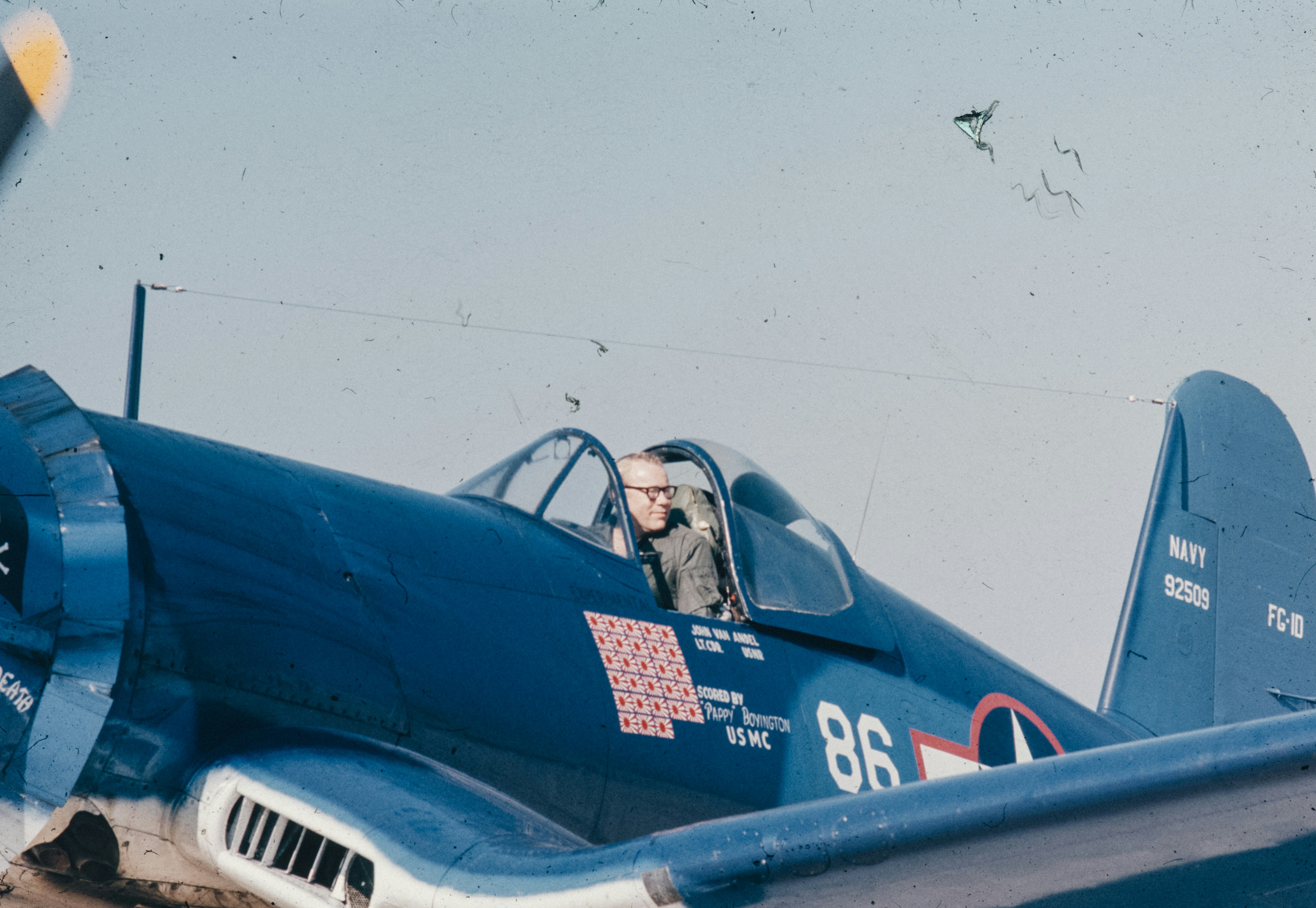 A blue fighter plane with a pilot in the cockpit, 