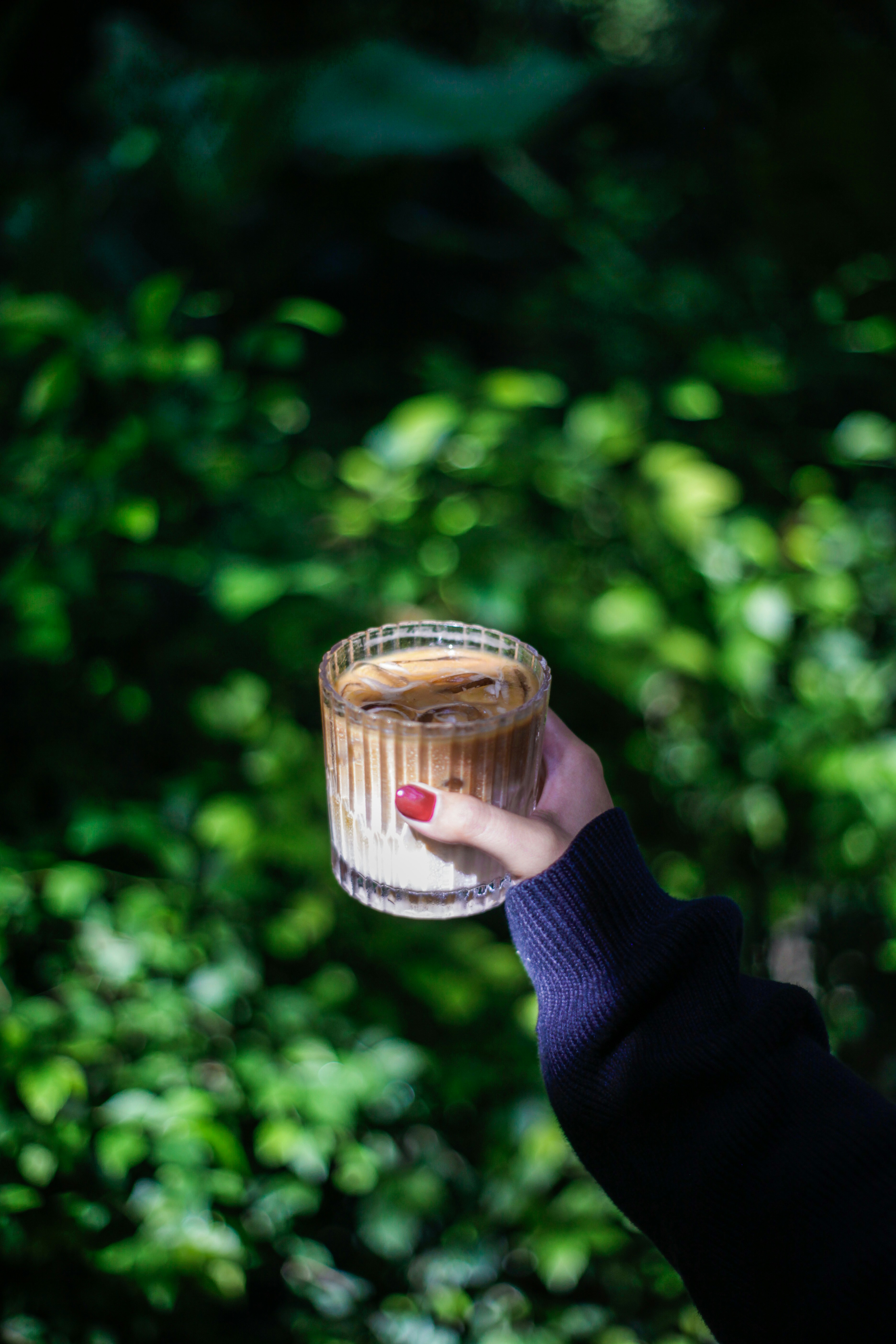 A person holding a glass with a liquid in it