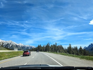 A car driving down a road with mountains in the background