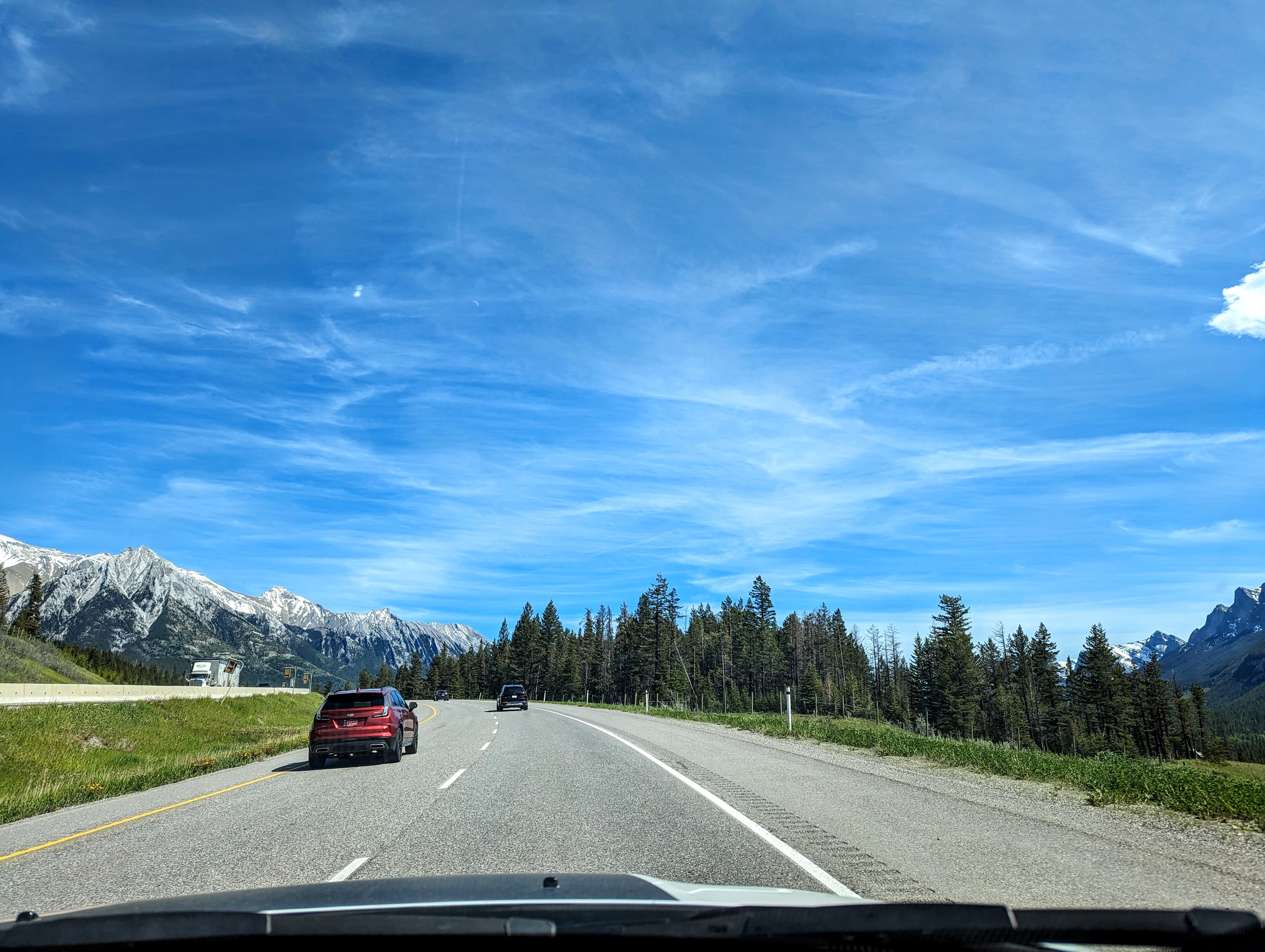 Une voiture roule sur une route bordée de montagnes