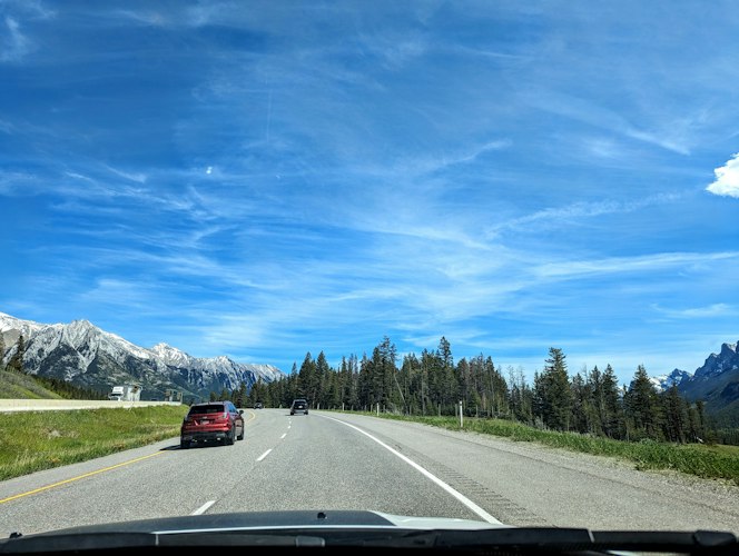 A car packed for a road trip parked beside an open highway