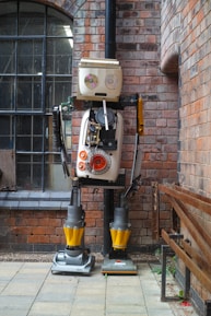 A robot standing in front of a brick building