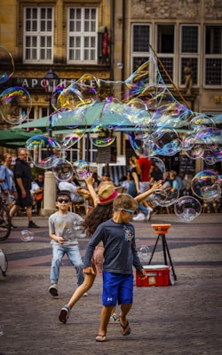 A group of children playing with bubbles in the street