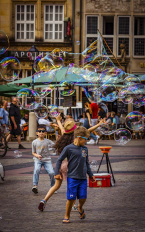 A group of children playing with bubbles in the street