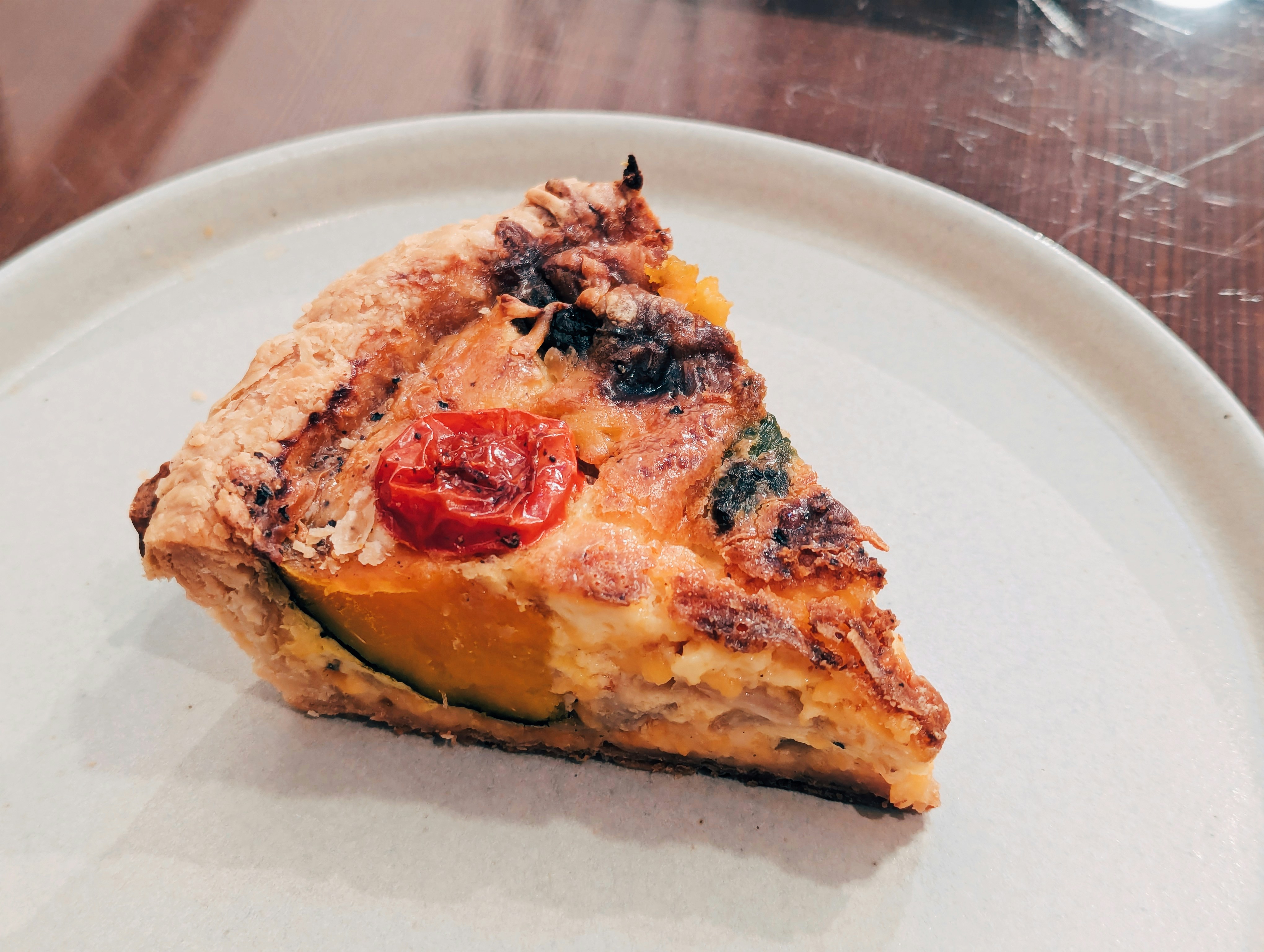 A piece of pizza on a plate on a table