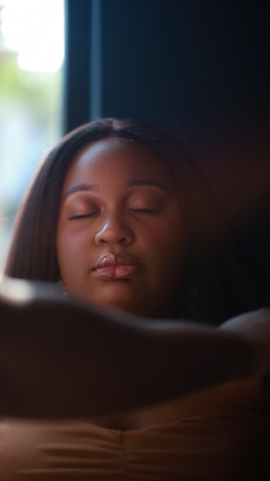 A woman laying on a bed with her eyes closed
