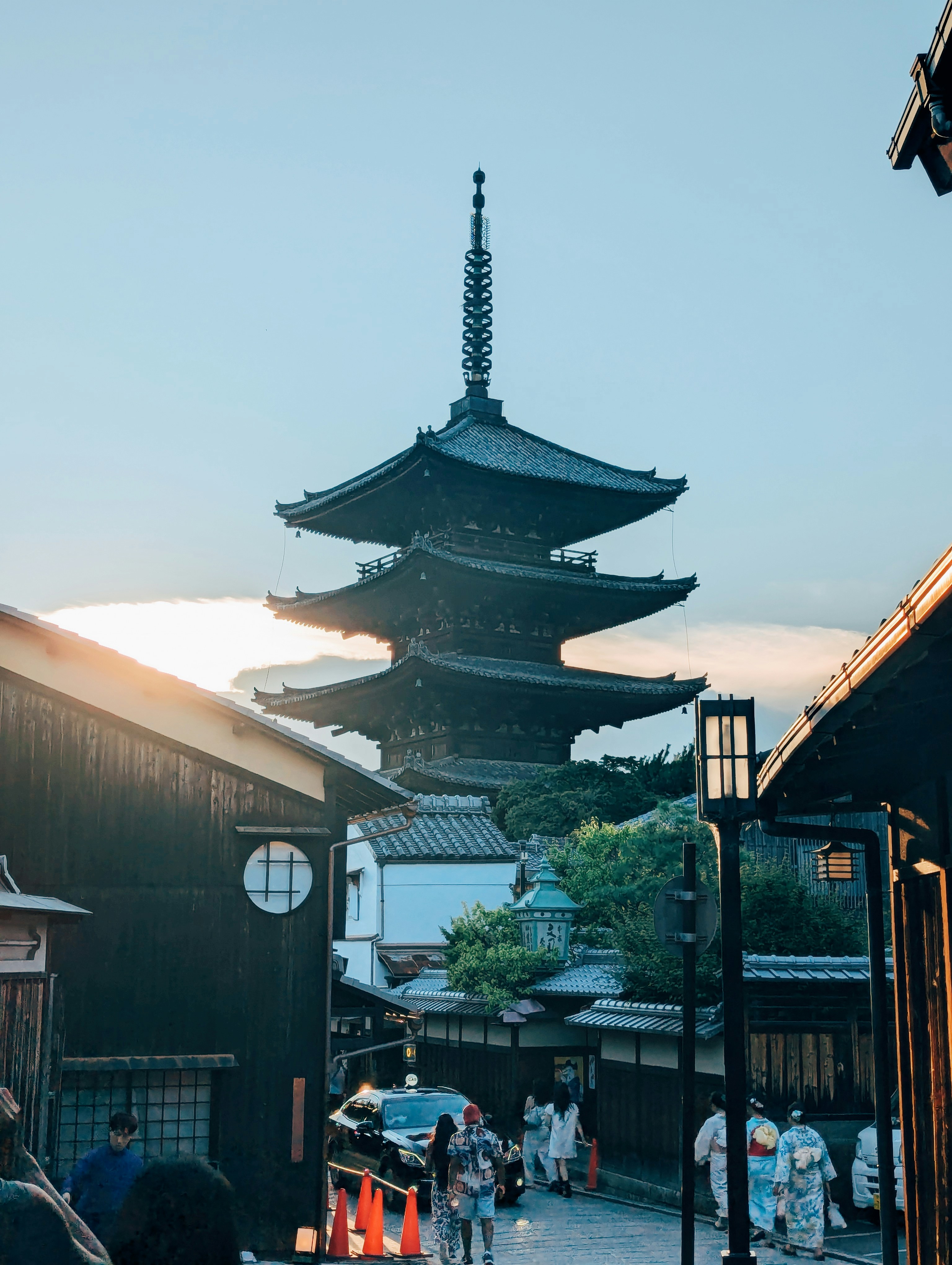 A group of people walking down a street next to tall buildings