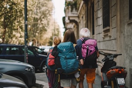 Two people with backpacks walking down the street