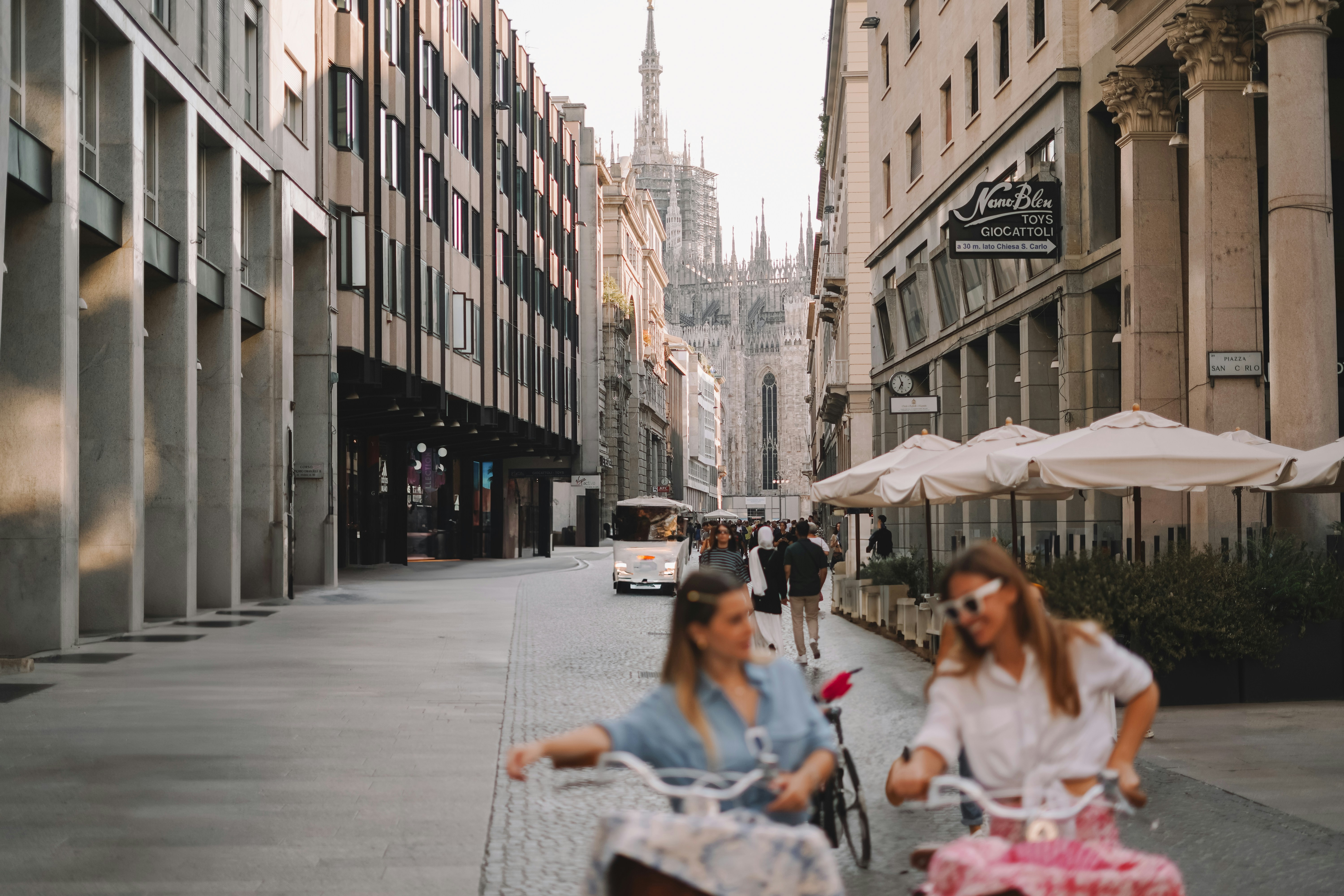 A couple of women riding bikes down a street