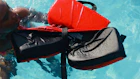 A man swimming in a pool with a life jacket on