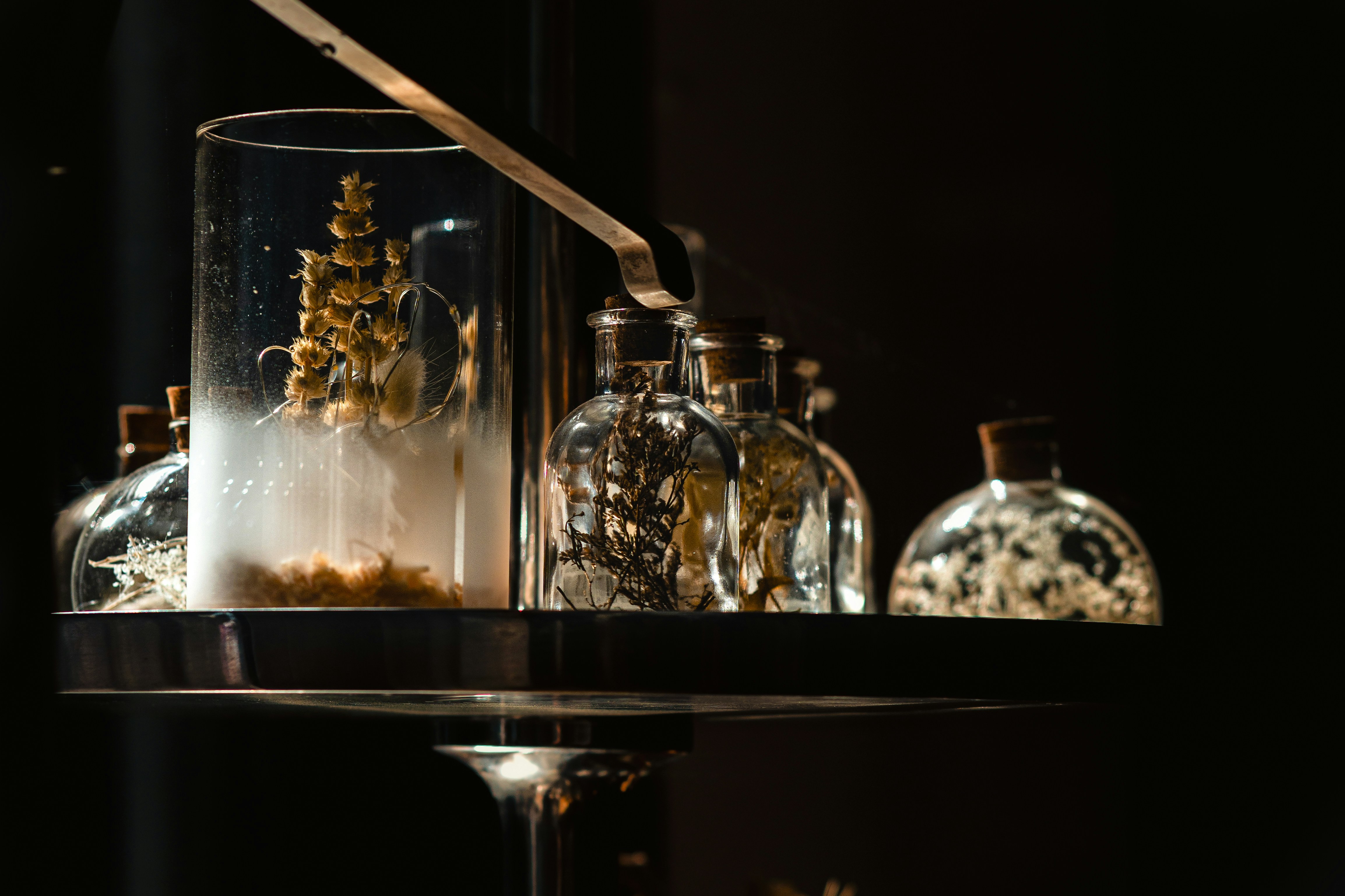 A table topped with lots of glass bottles filled with liquid
