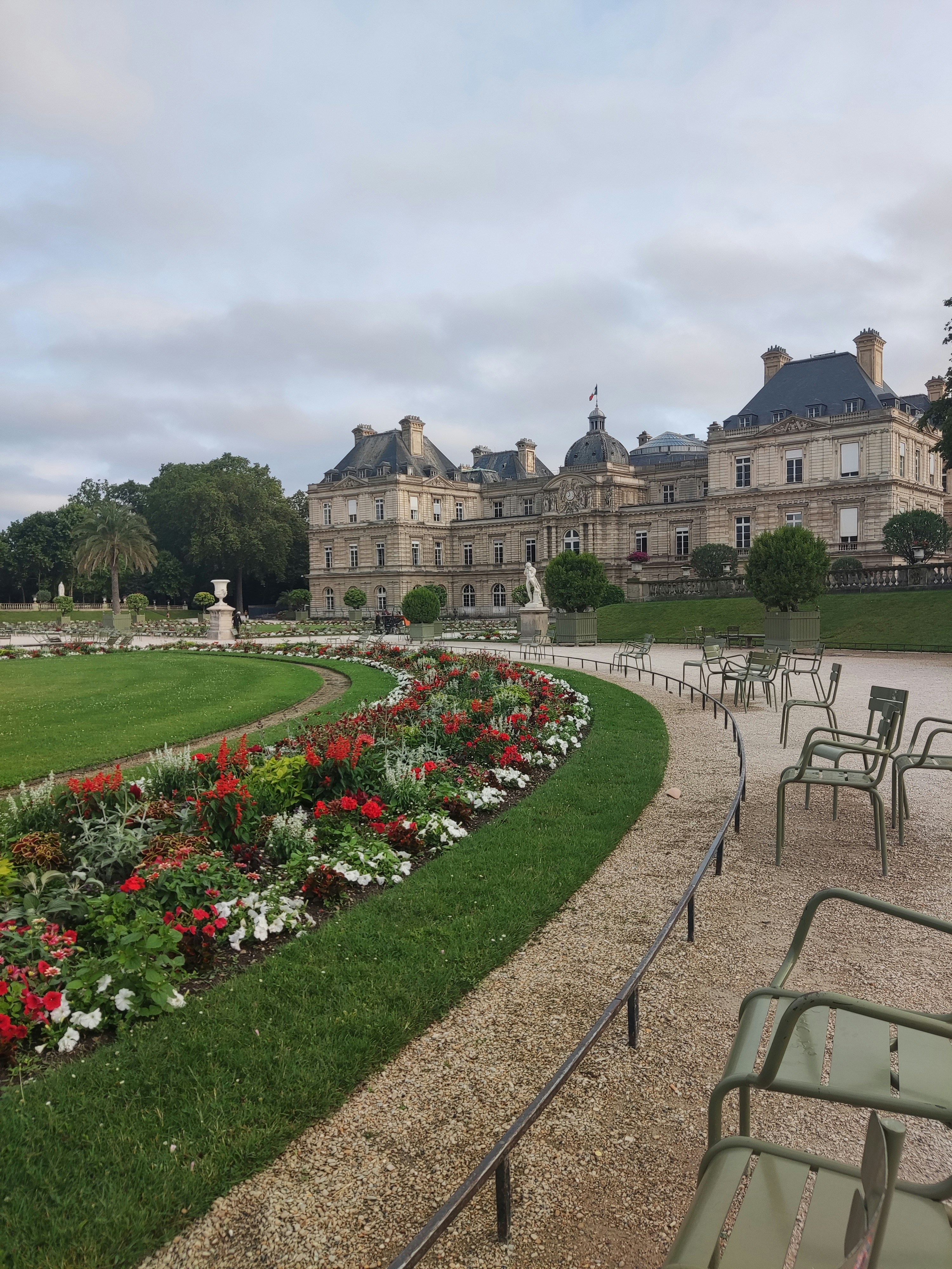 A row of lawn chairs sitting next to a lush green park