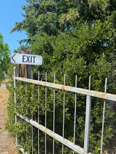A white exit sign sitting on the side of a road