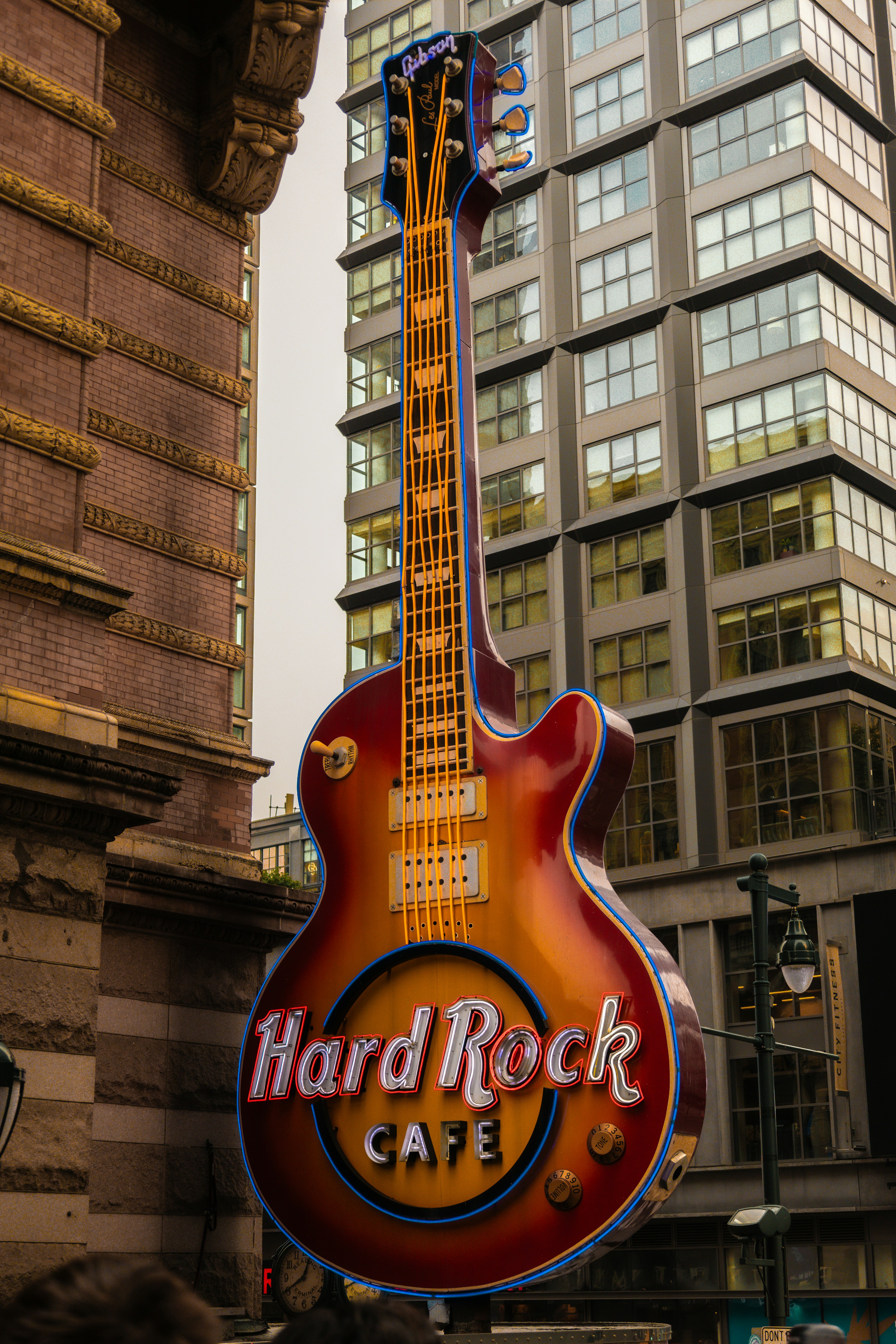 A guitar shaped sign on the side of a building