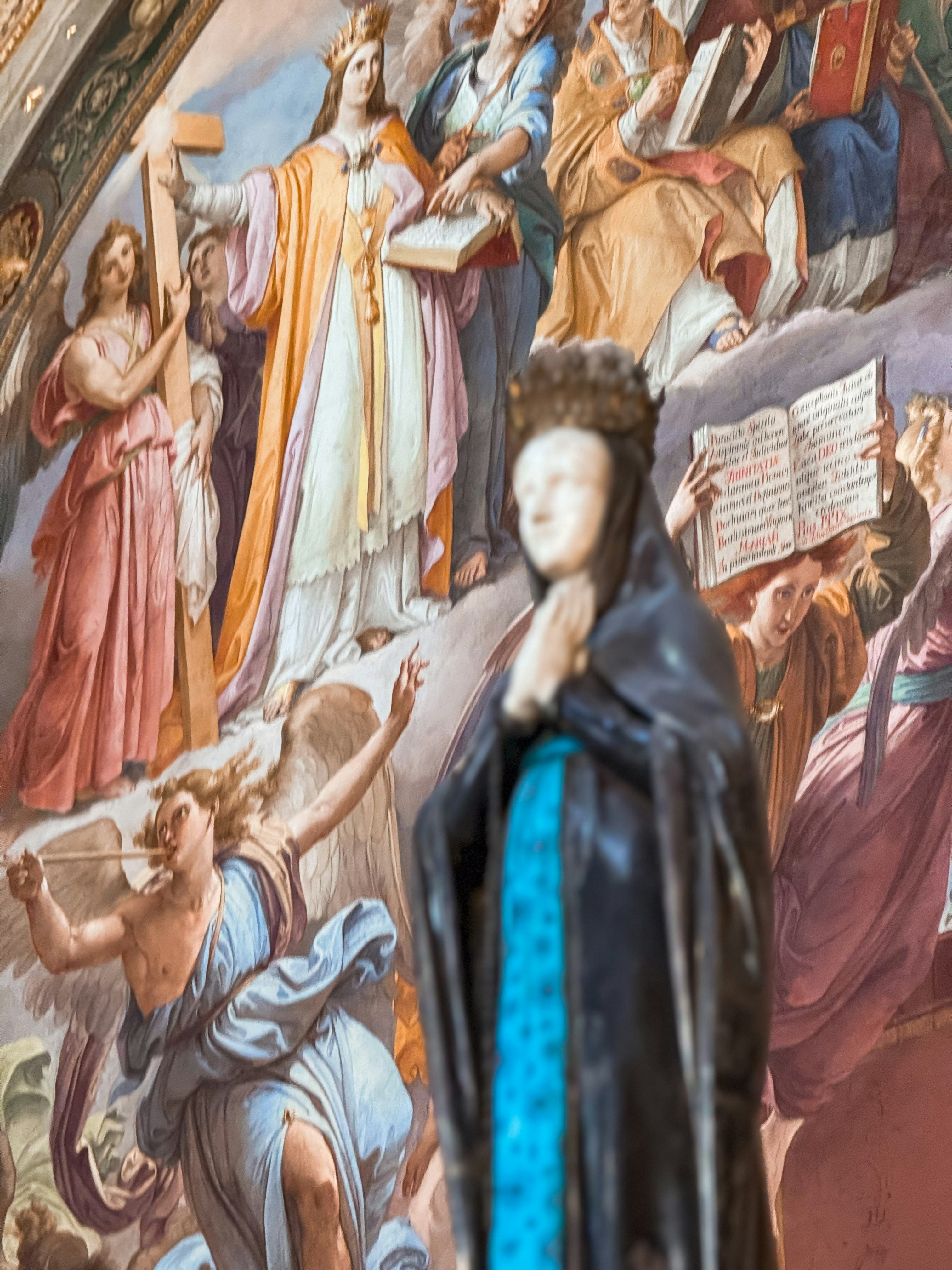 A statue of a woman standing in front of a painting