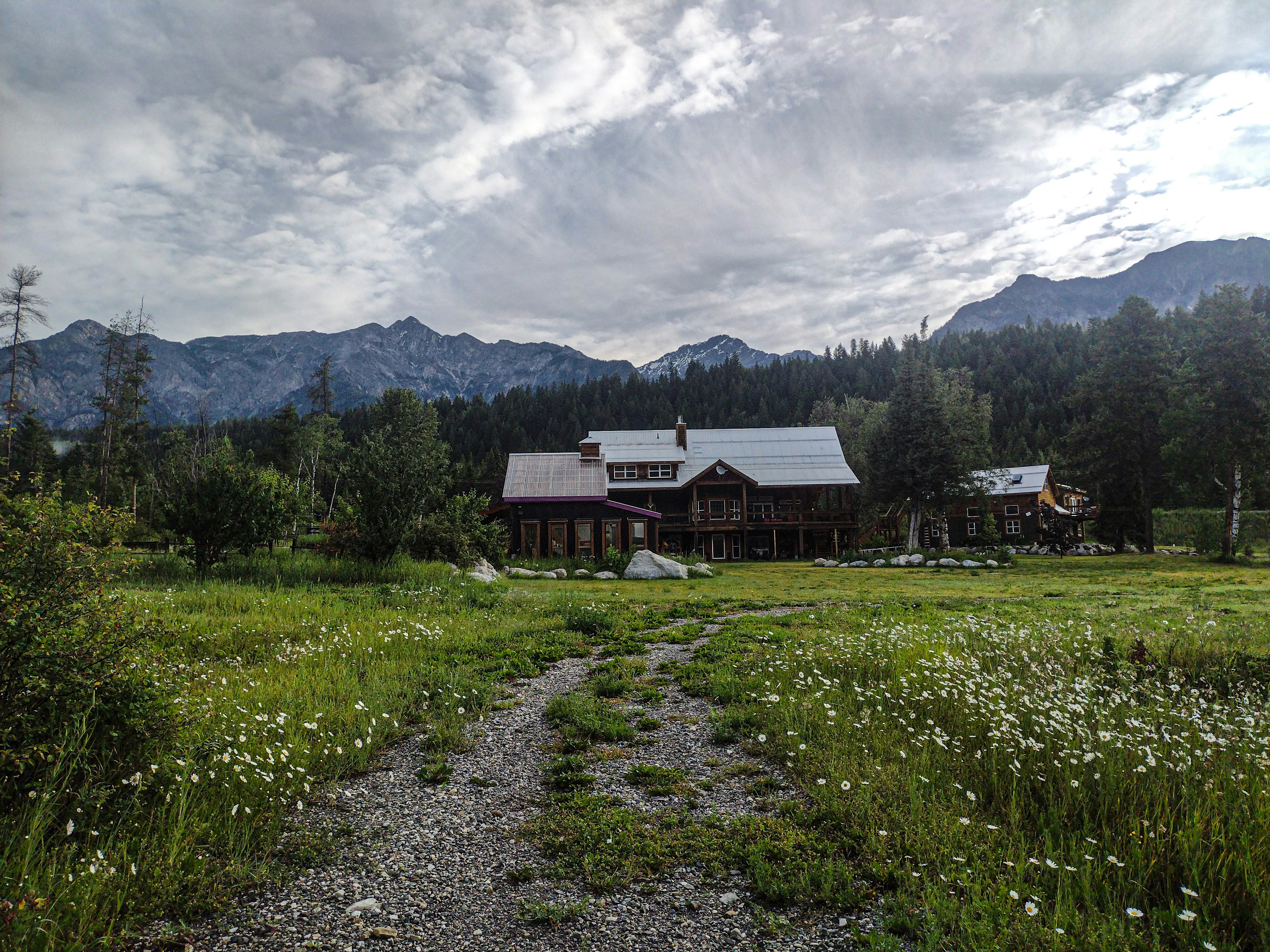 Un camino de tierra que conduce a una casa en las montañas