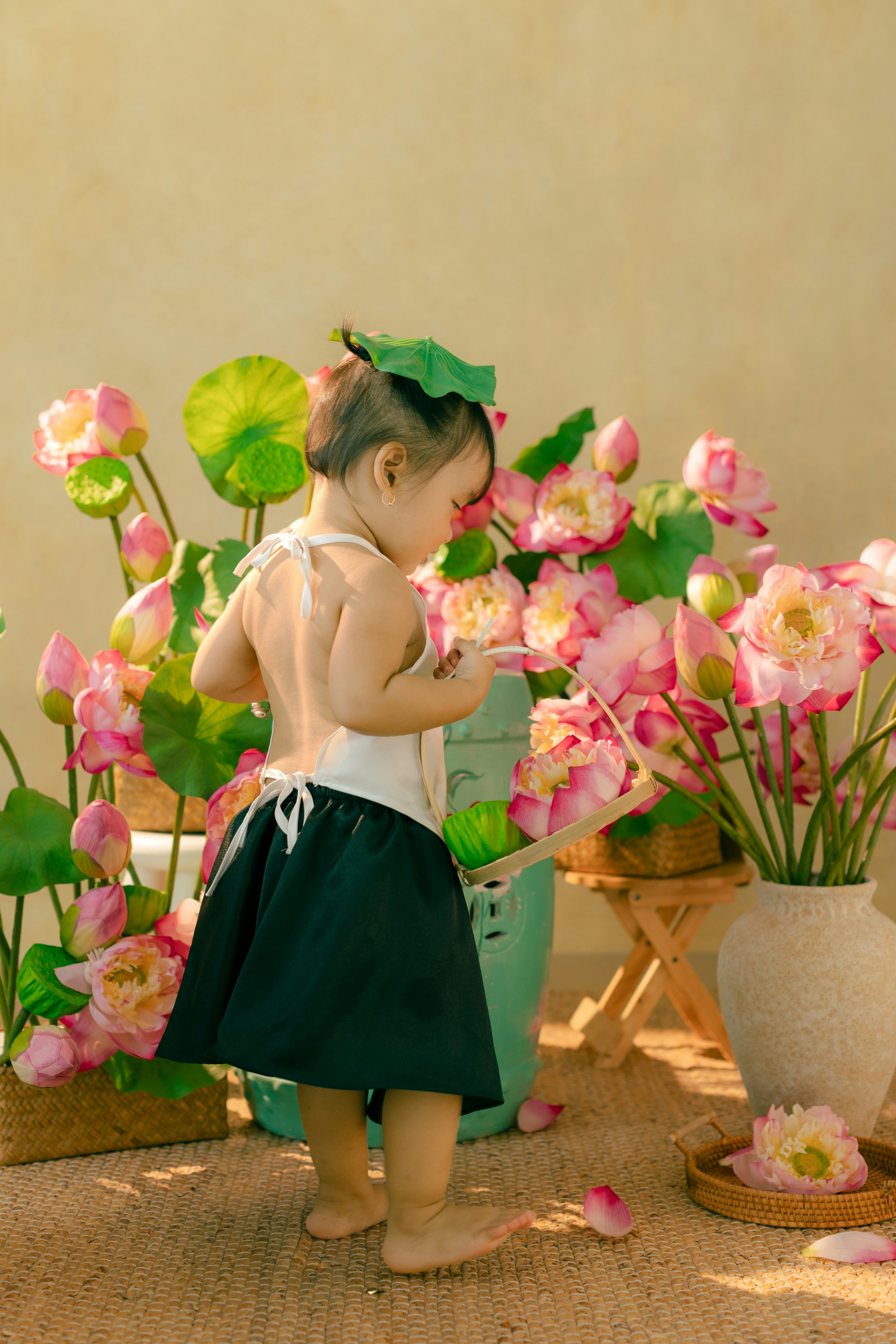 A little girl standing in front of a bunch of flowers