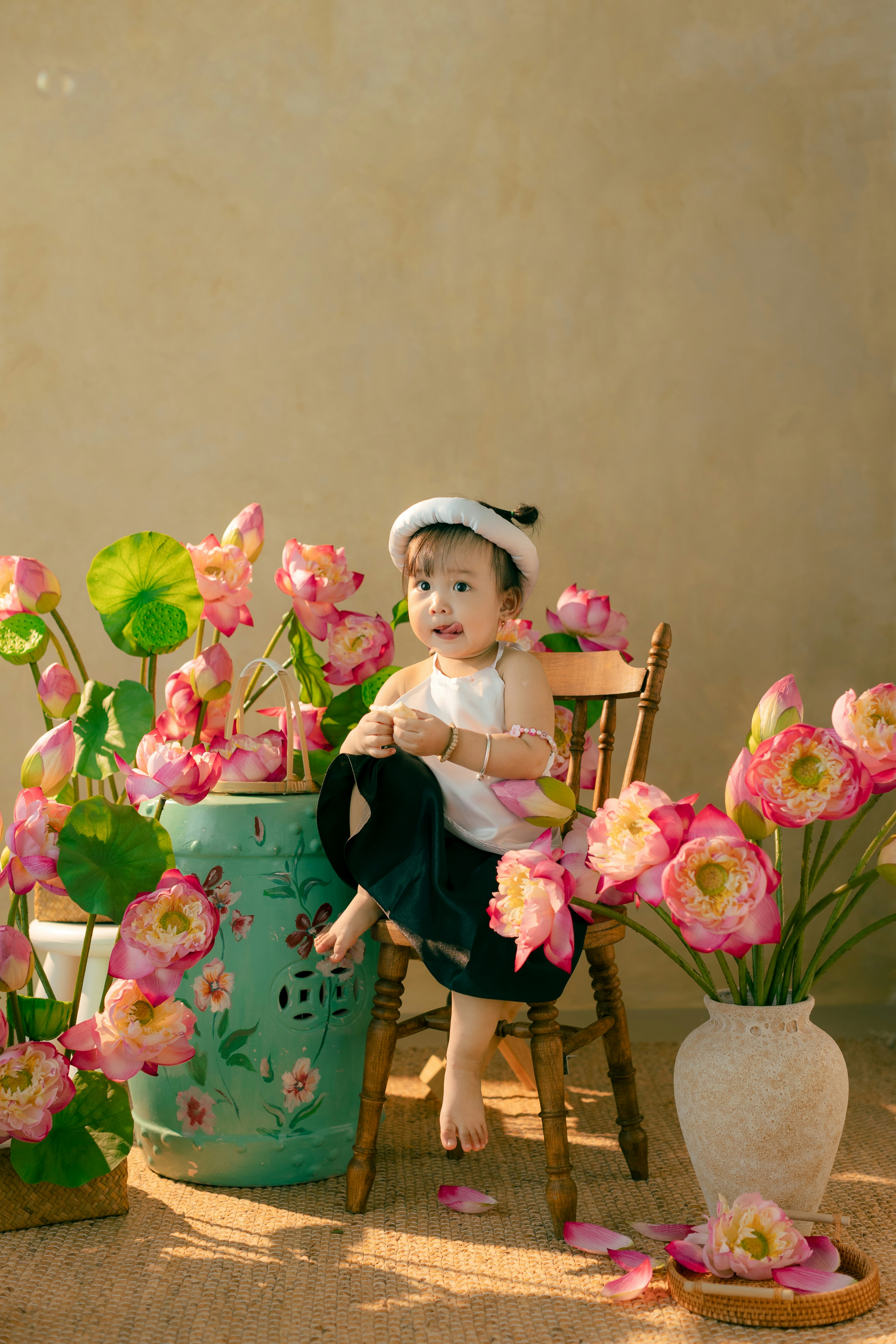 A baby sitting in a chair next to a bunch of flowers
