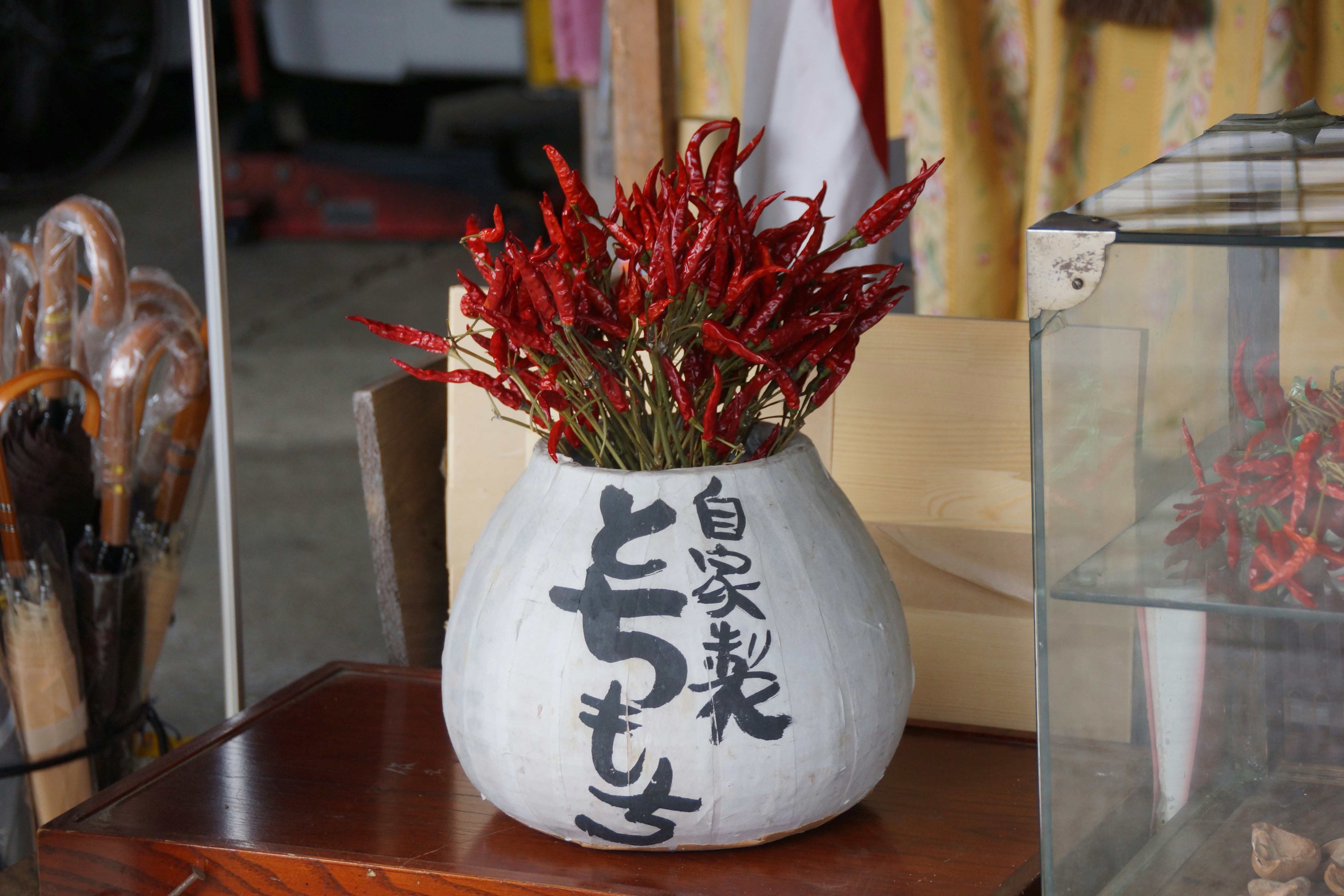 A vase filled with red flowers on top of a wooden table