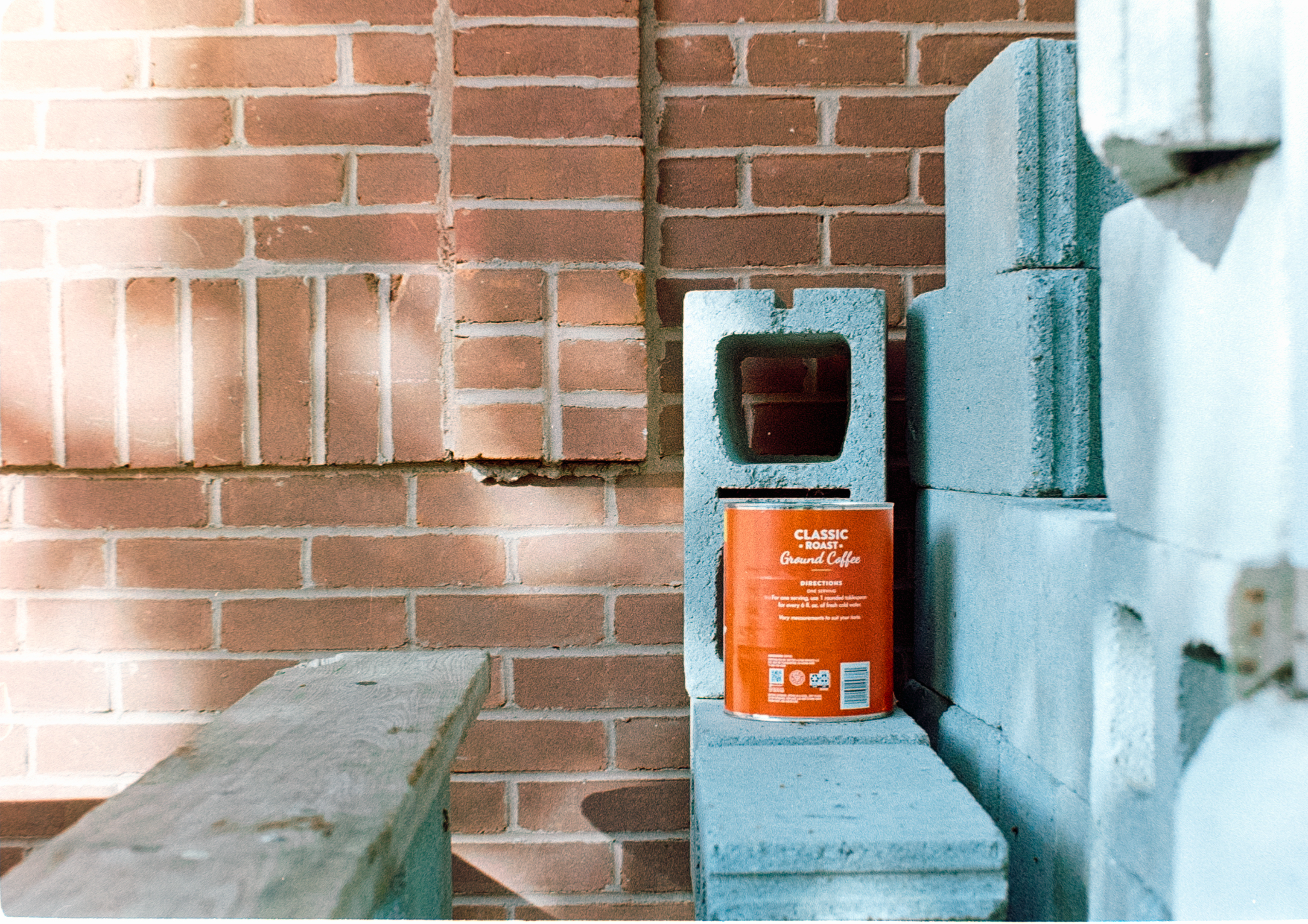 A brick wall with a cement bench and a brick wall behind it