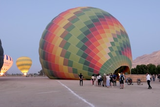 A group of people standing around a large hot air balloon