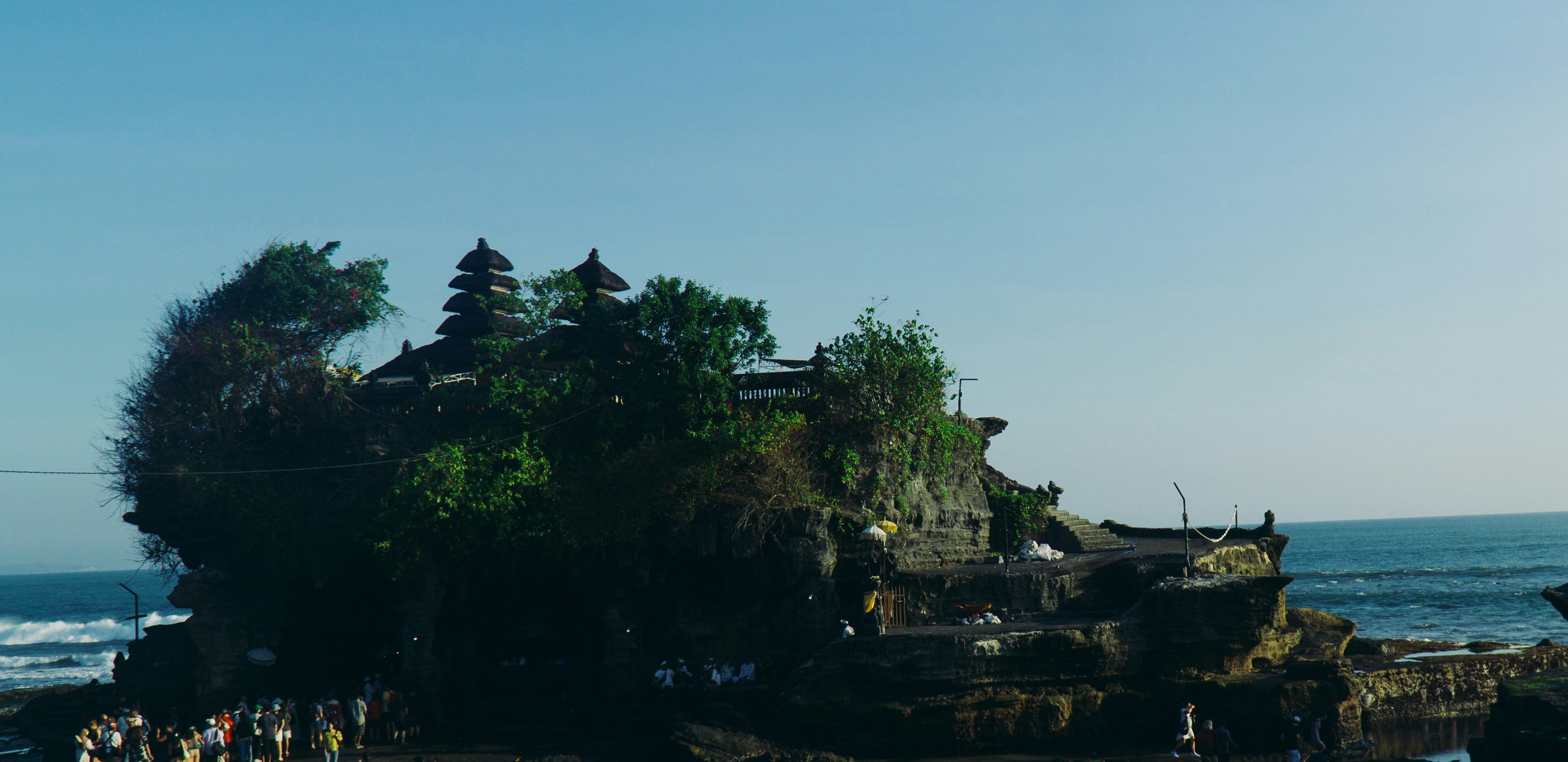 A group of people standing on top of a beach next to the ocean