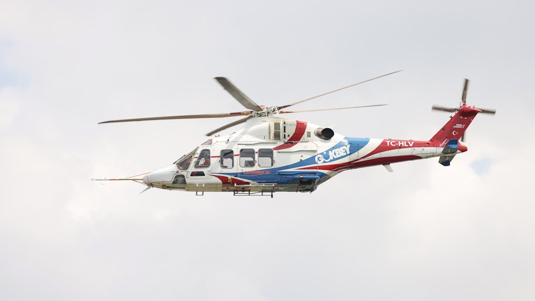 A red, white and blue helicopter flying in the sky, The T625 Gökbey helicopter, designed for multi-purpose use, is seen soaring through the sky.