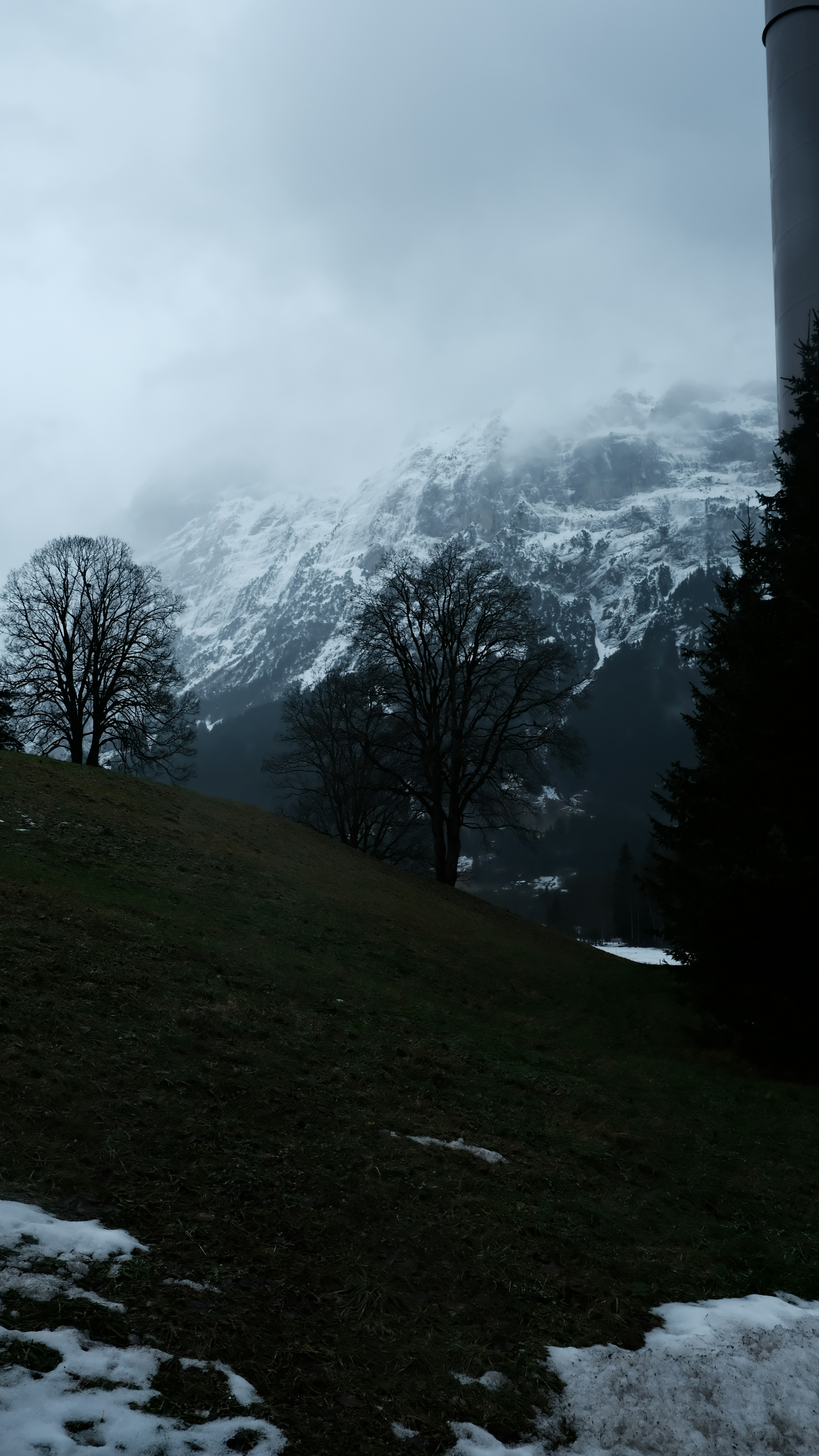 A view of a snowy mountain range with a silo in the foreground