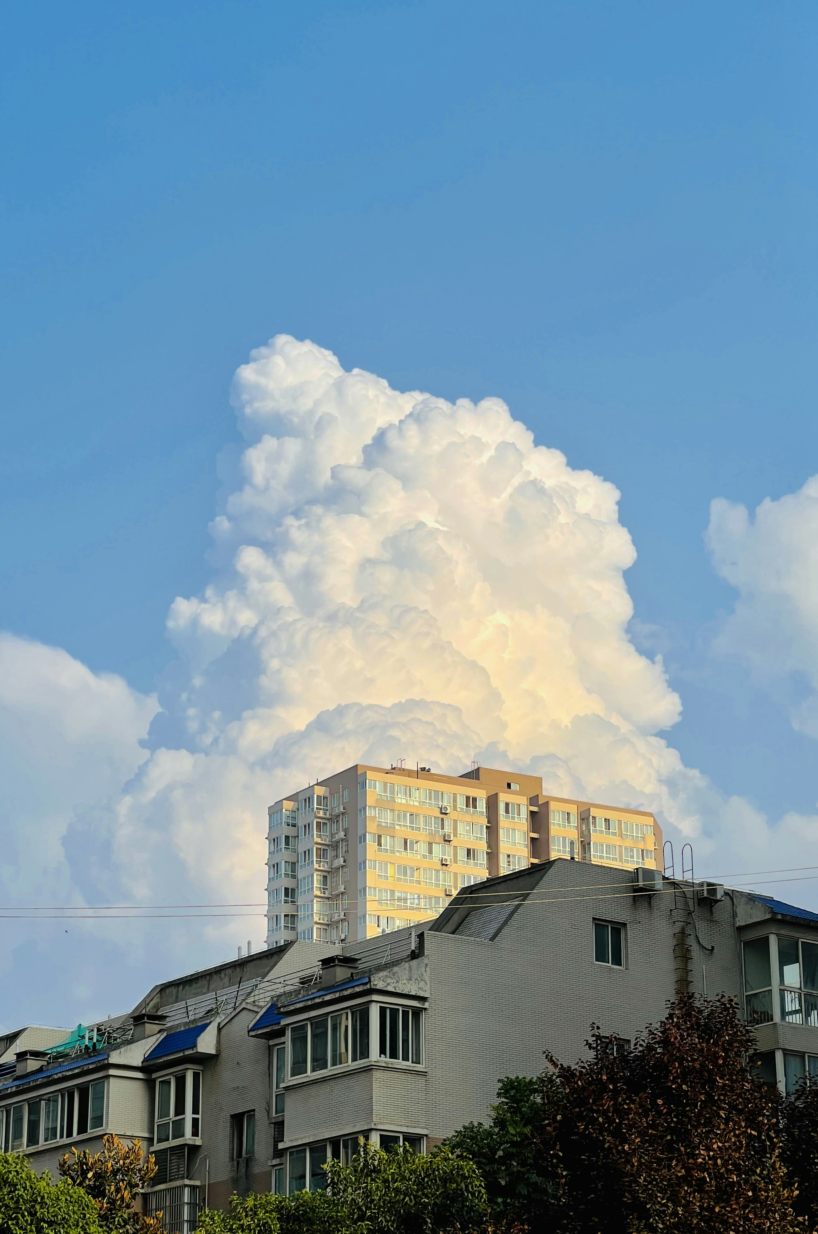 A very tall building with a lot of clouds in the sky photo – Free Sun ...