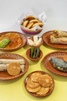 A table topped with lots of plates of food