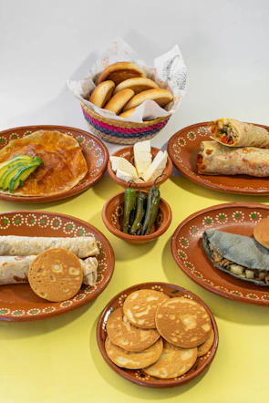 A table topped with lots of plates of food
