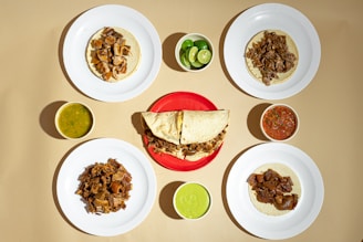 A table topped with plates of food and condiments