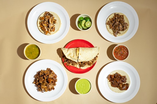 A table topped with plates of food and condiments