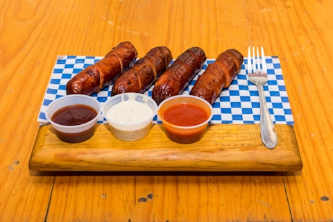 A wooden tray topped with lots of hot dogs