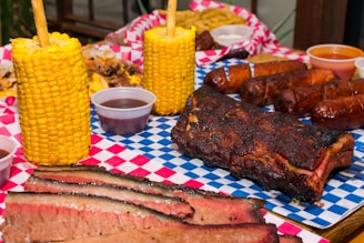 A table topped with corn, ribs and corn on the cob